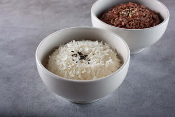 A view of bowls of rice, featuring steamed white rice and colored brown rice.