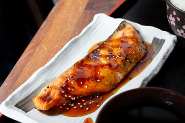 A view of a salmon filet topped with teriyaki sauce.