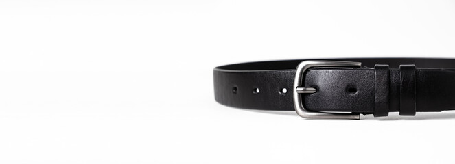Black leather belt for trousers and jeans. Fastened fashionable men leather belt with dark chrome matted metal buckle isolated on white background. Male accessory. Luxury strap. Haberdashery goods