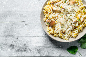 Fusilli pasta with mushrooms, cheese and mint leaves.