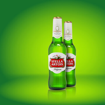 Bottle of Stella Artois beer on light green background, premium Belgium pilsner beer