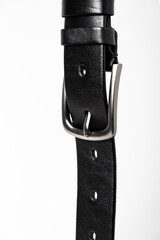 Black leather belt for trousers and jeans. Fastened fashionable men leather belt with dark chrome matted metal buckle isolated on white background. Male accessory. Luxury strap. Haberdashery goods