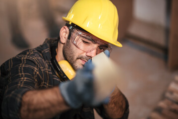 Young attractive caucasian man carpenter working in small business diy timber workshop. Wood industry and furniture industrial.