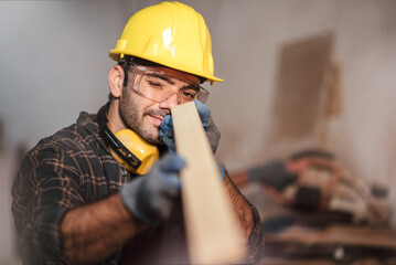 Young attractive caucasian man carpenter working in small business diy timber workshop. Wood industry and furniture industrial.