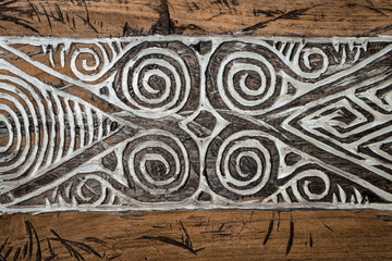 Balinese wood carving. A pattern of curls on the aged wood surface.