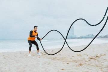 young athlete training in the morning on the beach with ropes