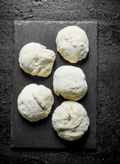 Pieces of dough on a stone Board.