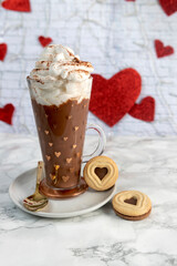 Cup of chocolate with cream and cookies with hearts on background of hearts on white marble, vertical