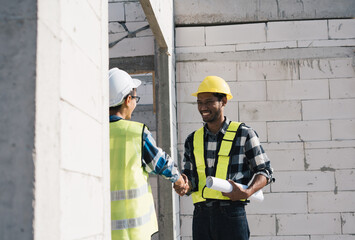 group asian engineer shaking hands on construction site.
