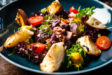 Warm chicken liver salad with port wine-honey sauce. Carrot cream, bacon, cherry tomatoes, brioche. Delicious healthy traditional food closeup served for lunch in modern gourmet cuisine restaurant