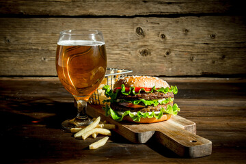 Burger with beer in a glass and fries.