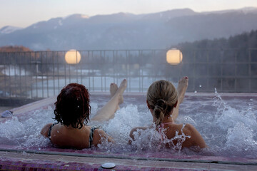 People, enjoying whirlpool and saunta after day of skiing, relaxing in nice warl whirlpool outdoor,...
