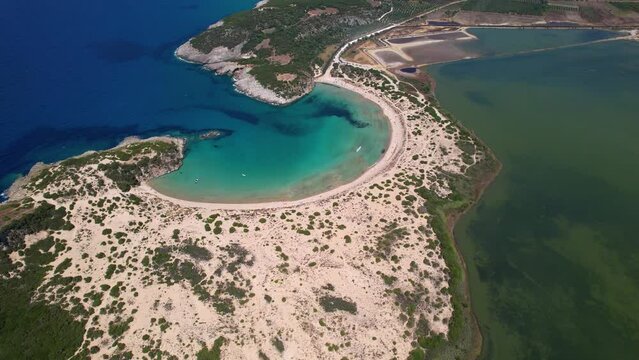 Aerial drone video of the iconic  semicircular sandy beach of Voidokoilia in Messinia, Gialova, Peloponnese, Greece