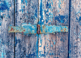 peeling blue paint on an old wooden door