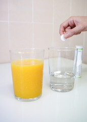 an orange juice and a pills in water. cold and illness immunity