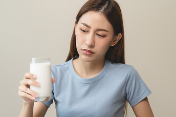 lactose intolerance concept. Woman pushing glass of milk deny to drink.