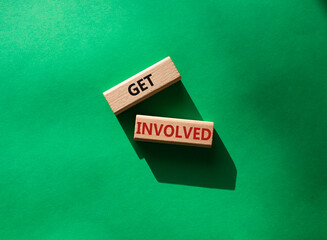 Get involved symbol. Wooden blocks with words Get involved. Beautiful green background. Business and Get involved concept. Copy space.