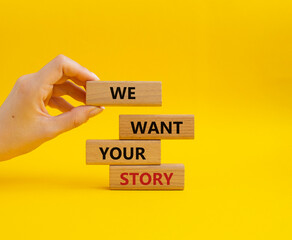 We want your story symbol. Concept words We want your story on wooden blocks. Beautiful yellow background. Businessman hand. Business and We want your story concept. Copy space.