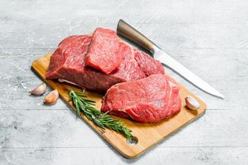 Raw meat.Pieces of fresh beef with rosemary branches.