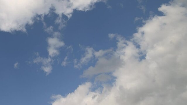 timelapse video with white clouds running on blue sky. cloudscape with pure white cumulus clouds
