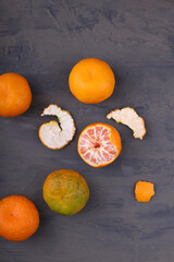 Tangerines (oranges, tangerines, clementines, citrus fruits) on a dark slate, stone or concrete background. Gray background. View from above. Space for text