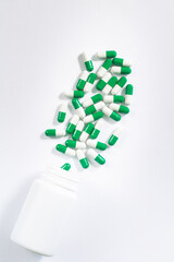 pills and bottle on white background,White medicine capsules spill out from transparent bottle