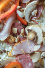 freshly made pizza close-up; details of the pizza application; juicy pizza from the oven with mushrooms, tomatoes and bacon and sprinkled with parmesan cheese