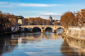 Fototapeta premium Bridge over the Tiber river in Rome with a view in the distance of Saint Peter's Basilica