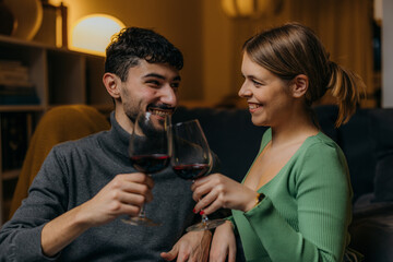 A man and a woman drink wine together and celebrate their relationship