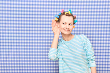 Happy young woman with colorful hair curlers on head