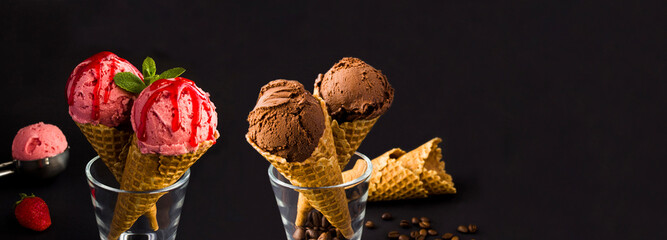Chocolate and strawberry  ice cream and in the waffle cone on the black background. Banner. Copy...
