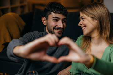 Close up view of a couple making a shape of a hart with their hands