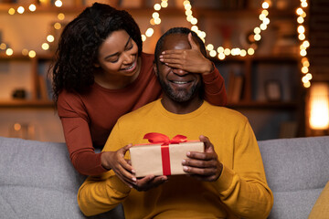 Loving african american woman making birthday surprise for husband