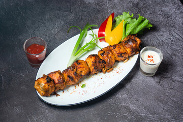 Spicy Chicken Tikka boti kabab with chutney, raita, salad served in dish isolated on grey...