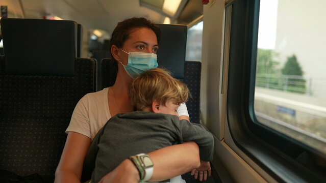 Mother Holding Baby Toddler Traveling By Train Wearing Covid Face Mask During Pandemic