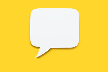 Paper speech bubble in the shape of a rectangle on a yellow background. Flat white chat icon in the form of an empty speech bubble. Free space for text or image. Internet communication concept - obrazy, fototapety, plakaty