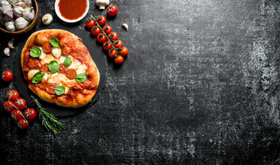 Homemade pizza with cherry tomatoes, spinach and garlic.