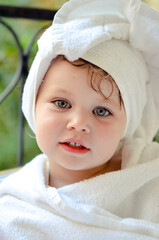 Cute portrait of a young girl getting out of the bath and waiting in the garden