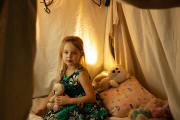 the girl is playing and reading a book in the hut