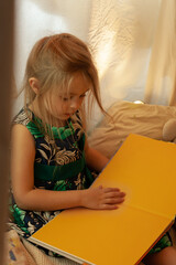 the girl is playing and reading a book in the hut