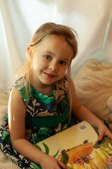 the girl is playing and reading a book in the hut