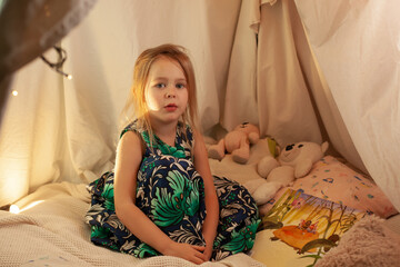 the girl is playing and reading a book in the hut