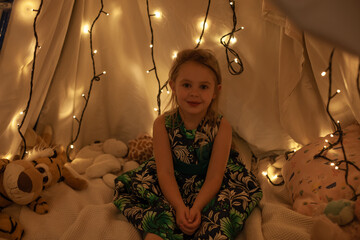 the girl is playing and reading a book in the hut