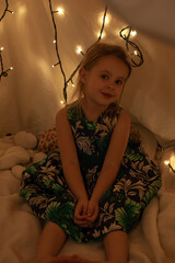 the girl is playing and reading a book in the hut