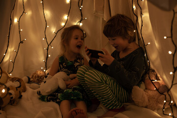 children sit in the hall and look at the tablet