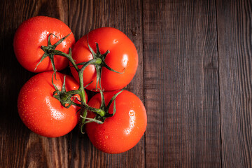 Tomatoes with water drops on wooden