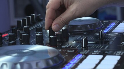 DJ hands mixing music on turntable, detail lateral view