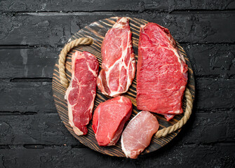 Raw meat. Beef and pork steaks on a wooden tray.