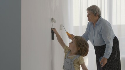Portrait of little child and old woman paint together, grandmother work lesson