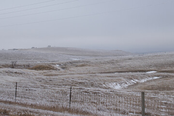 Frozen fence and grassland on a cold, foggy gray day in Gillette, Wyoming. - obrazy, fototapety, plakaty